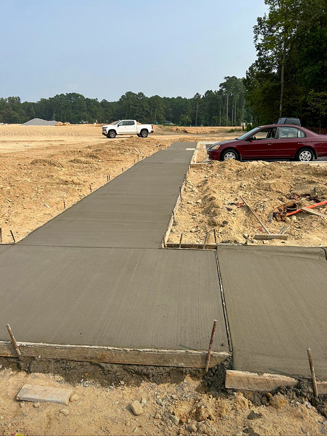 Newly-constructed concrete sidewalk with ADA access ramps.