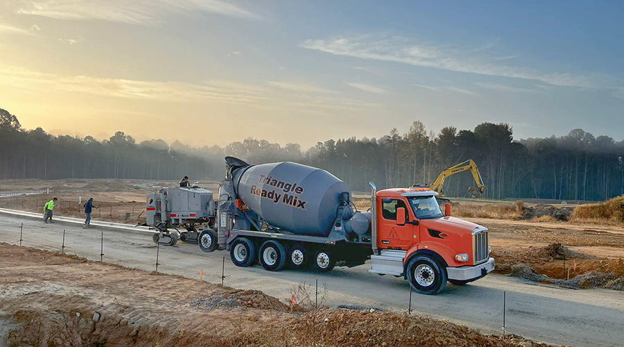 A curb & gutter machine crew form L&L Concrete construct a new concrete curb & gutter on a cold morning near Raleigh, NC.
